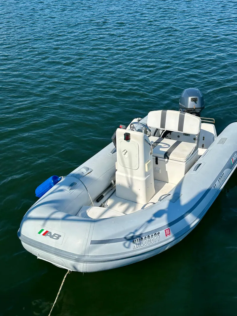 Slide: The Image of Small inflatable boat on water, featuring a motor and seating, near a Beneteau 57 yacht. - 24