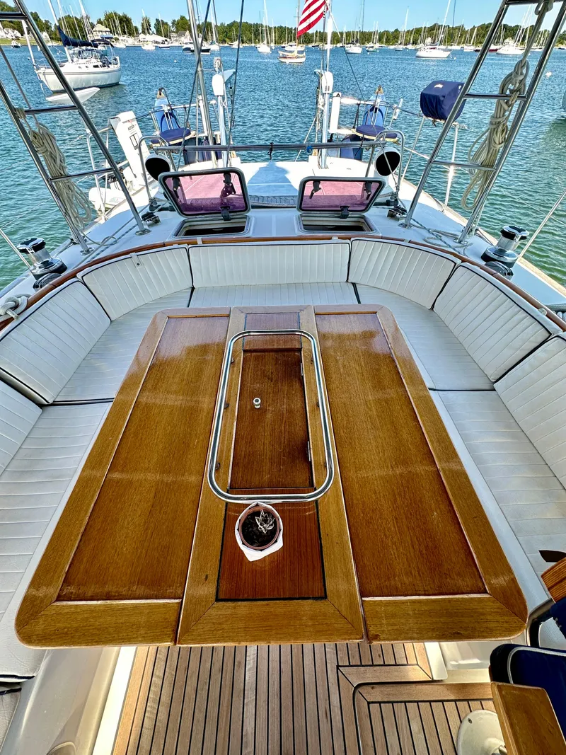 Slide: The Image of Luxurious 2010 Beneteau 57 yacht cockpit with wooden table and scenic marina view. - 31