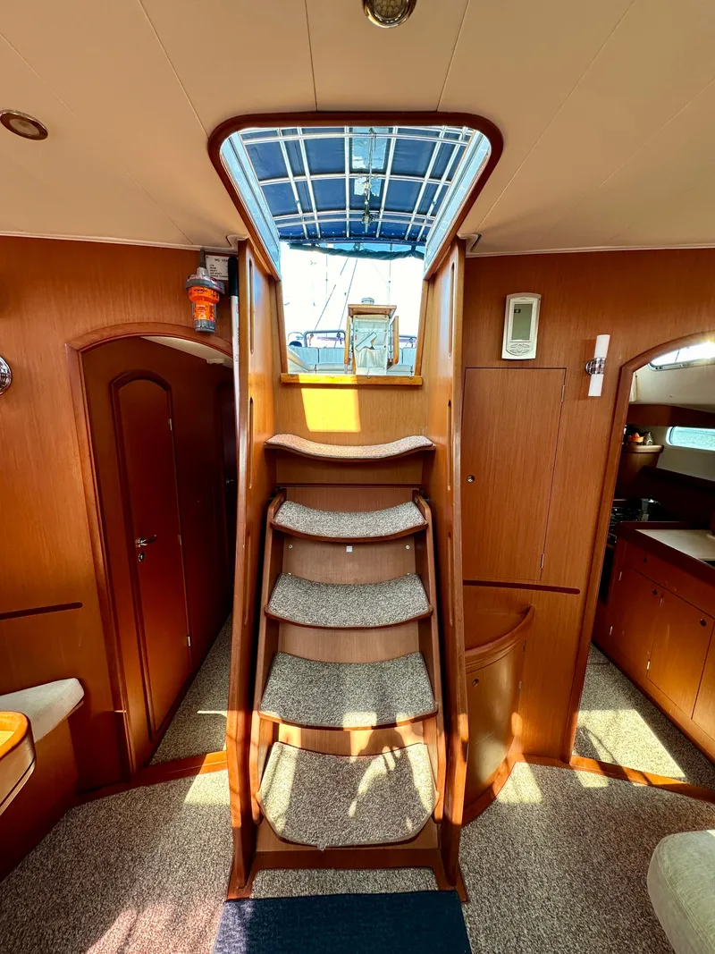 Slide: The Image of Interior of 2010 Beneteau 57 yacht with wooden stairs and cozy cabin design. - 33