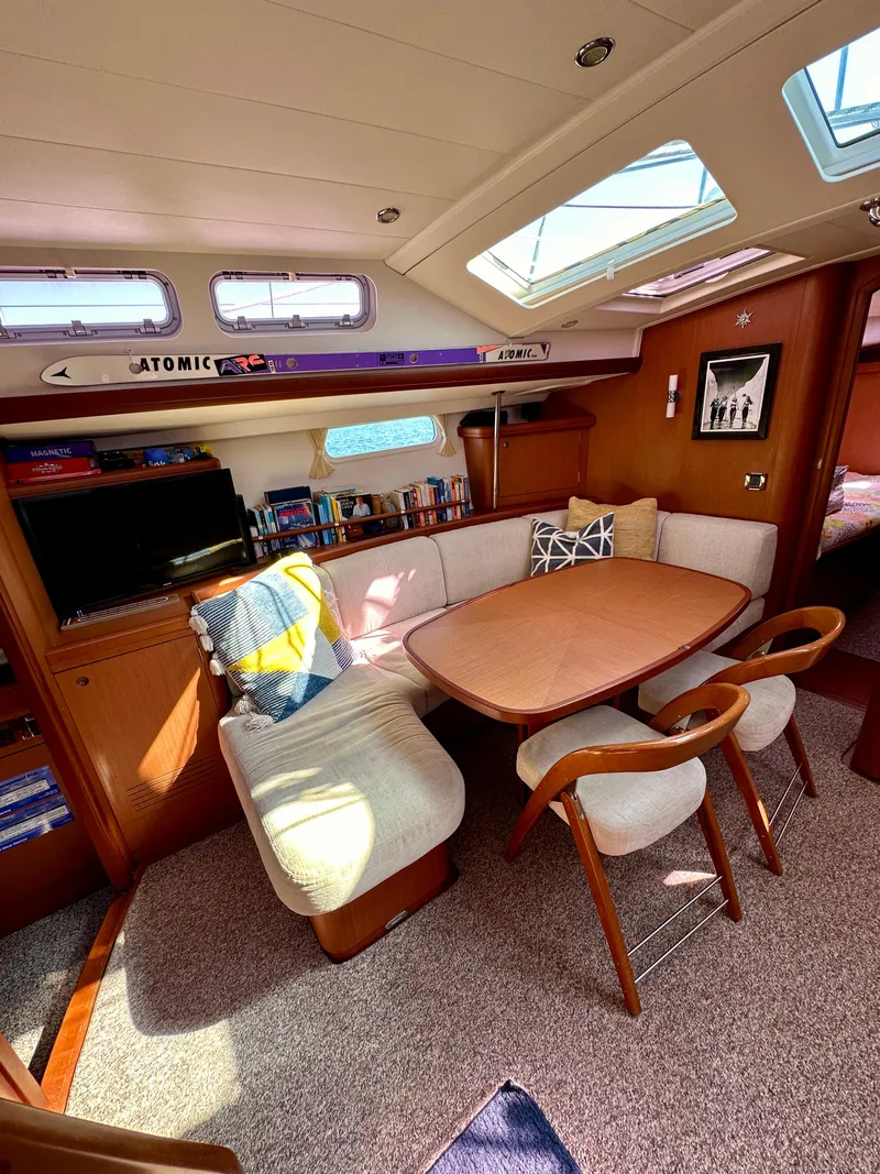 Slide: The Image of Interior of 2010 Beneteau 57 yacht with cozy dining area and natural light. - 37
