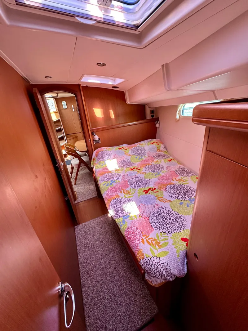 Slide: The Image of Cozy cabin interior of 2010 Beneteau 57 yacht with colorful bedding and wooden finish. - 46
