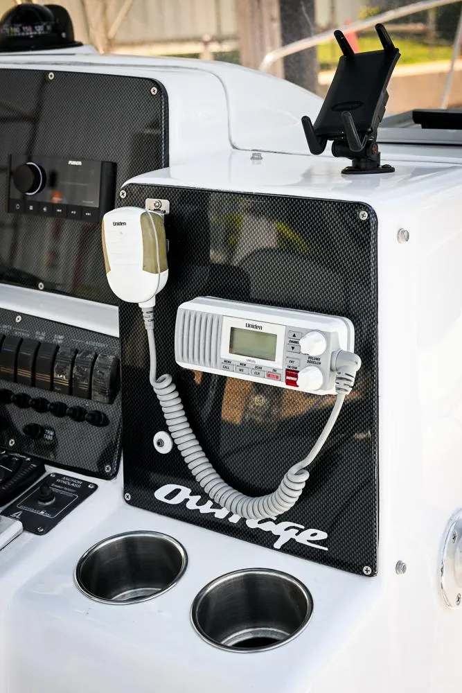 Slide: The Image of 1999 Boston Whaler 26 console with radio, cup holders, and carbon fiber panel. - 10