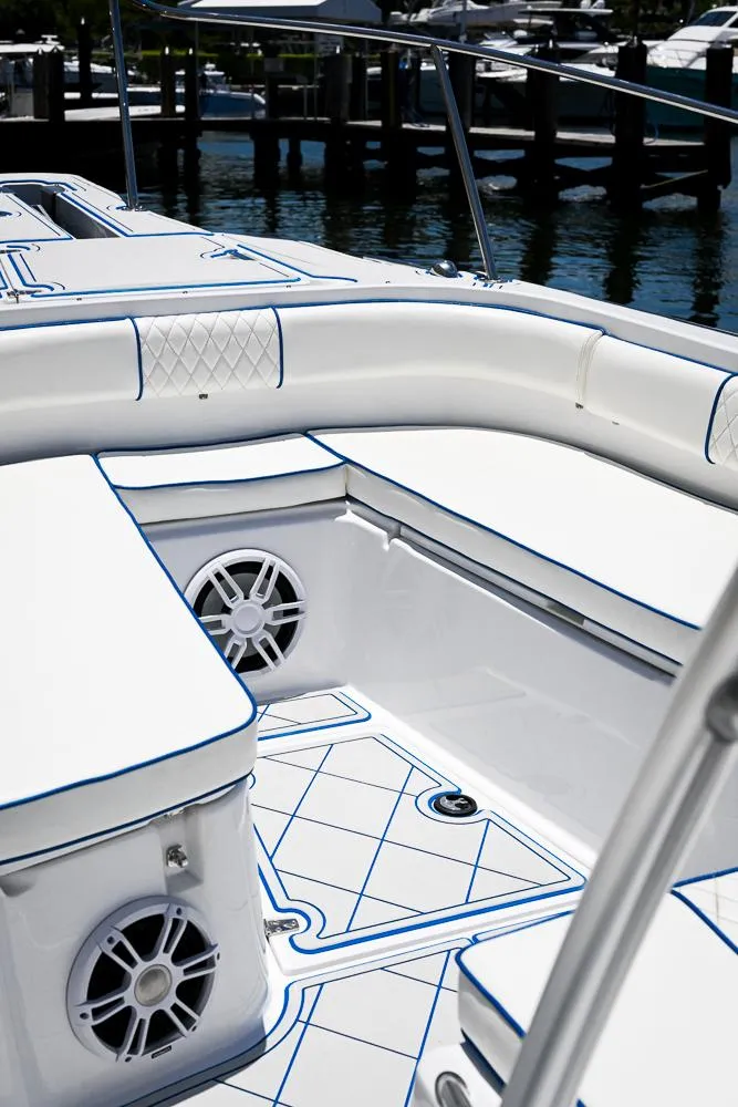 Slide: The Image of 1999 Boston Whaler 26 boat interior with white seating and blue trim. - 19