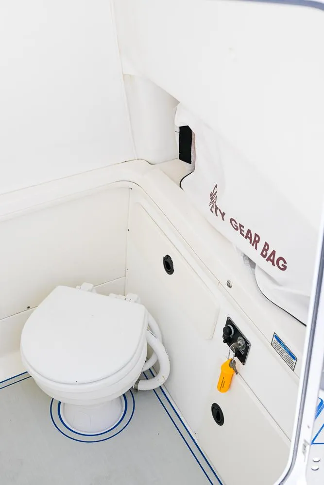Slide: The Image of 1999 Boston Whaler 26 boat interior with toilet and gear bag storage. - 20