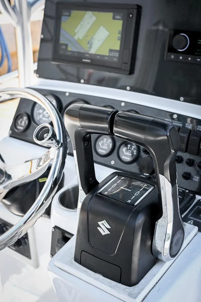 Slide: The Image of Control panel of a 1999 Boston Whaler 26 boat with steering wheel and throttle. - 7