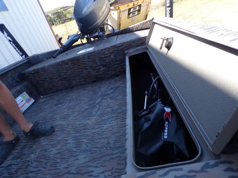 Slide: The Image of 2025 Xpress H18DB boat interior with storage compartment and motor. - 10