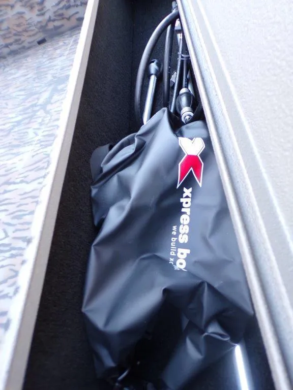 Slide: The Image of Xpress H18DB 2025 boat storage compartment with fishing rods and gear. - 11