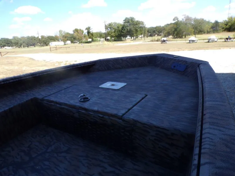 Slide: The Image of 2025 Xpress H18DB boat interior with camouflage design, parked outdoors. - 5