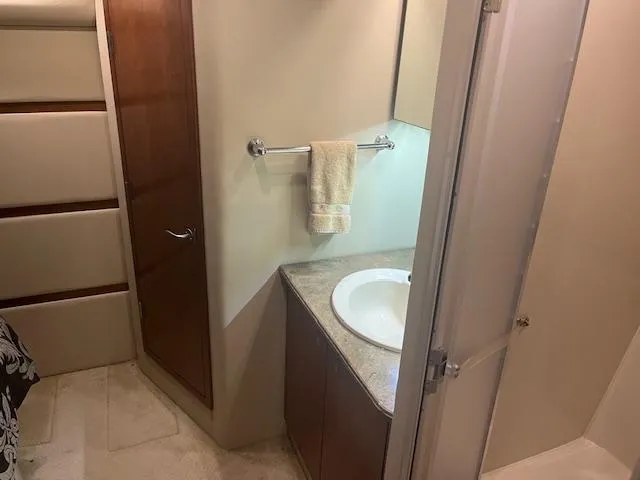 Slide: The Image of 2008 Cruisers Yachts 460 Express bathroom with sink, towel rack, and wooden cabinetry. - 20