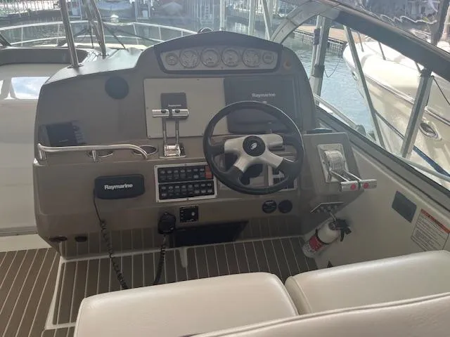 Slide: The Image of 2008 Cruisers Yachts 460 Express helm with Raymarine navigation system and steering wheel. - 7