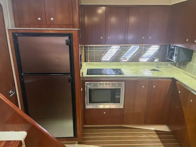 Slide: The Image of Luxurious 2008 Cruisers Yachts 460 Express kitchen with modern appliances and wood cabinetry. - 9