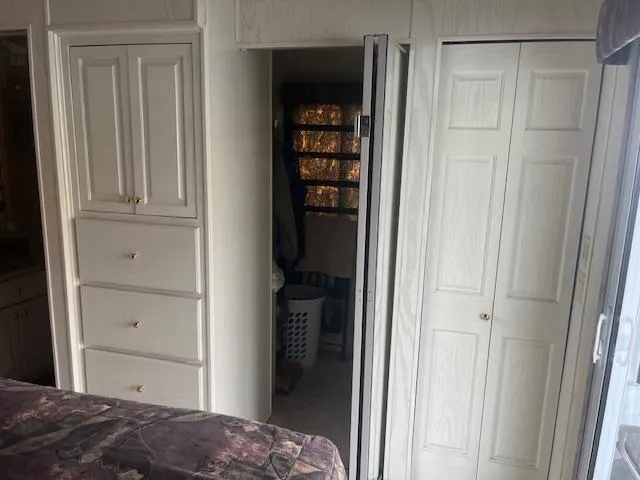 Slide: The Image of Interior of 2000 Sharpe 16X80 houseboat with white cabinets and closet. - 16