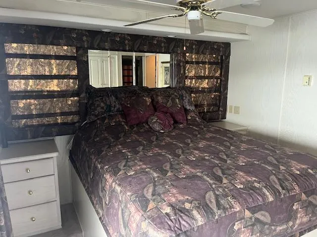 Slide: The Image of Cozy bedroom in 2000 Sharpe 16X80 houseboat with patterned bedding and ceiling fan. - 17