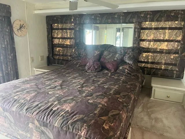 Slide: The Image of Cozy bedroom in 2000 Sharpe 16X80 houseboat with patterned bedding and mirrored headboard. - 18