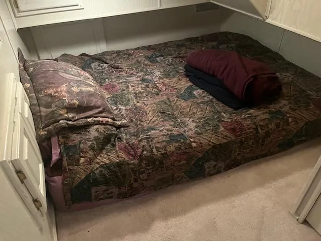 Slide: The Image of Cozy bedroom in 2000 Sharpe 16X80 houseboat with patterned bedding and folded blankets. - 21