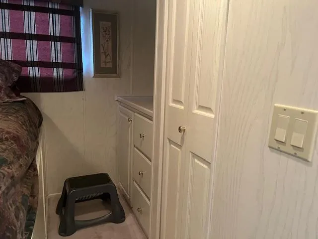 Slide: The Image of Interior of 2000 Sharpe 16X80 houseboat with storage cabinets and step stool. - 23