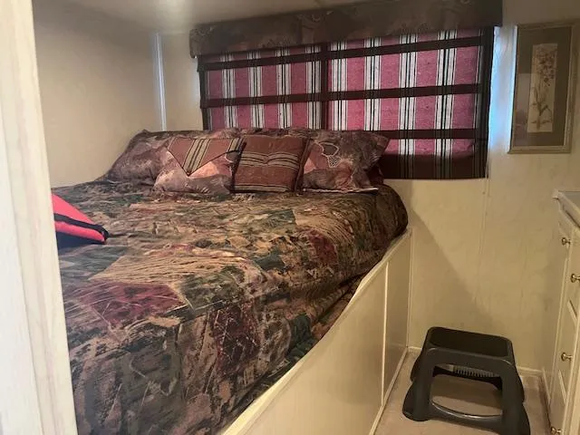 Slide: The Image of Cozy bedroom in 2000 Sharpe 16X80 houseboat with patterned bedding and window blinds. - 24