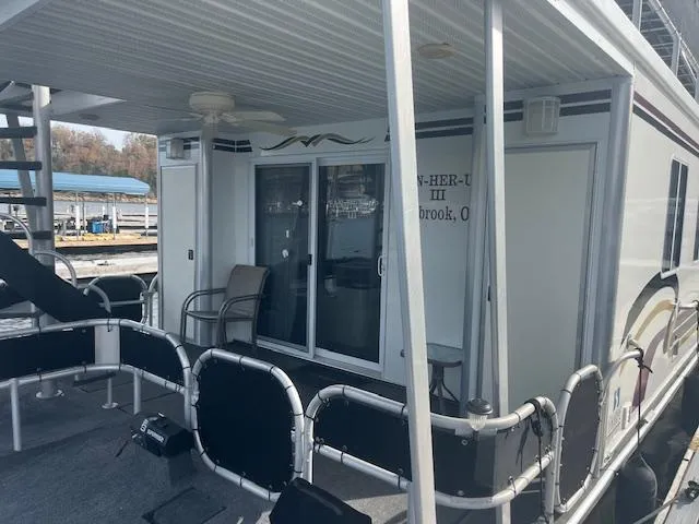 Slide: The Image of 2000 Sharpe 16X80 houseboat docked, featuring outdoor seating and sliding glass doors. - 26