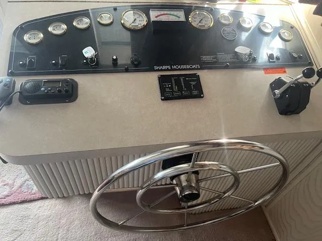 Slide: The Image of Control panel of a 2000 Sharpe 16X80 Houseboat with steering wheel and gauges. - 3
