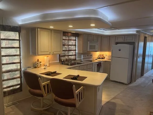 Slide: The Image of Interior of 2000 Sharpe 16X80 Houseboat with modern kitchen and cozy seating. - 7