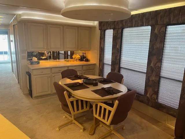 Slide: The Image of Dining area in 2000 Sharpe 16X80 houseboat with table, chairs, and cabinetry. - 9