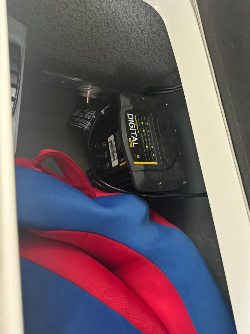 Slide: The Image of Digital charger in a 2018 Starcraft Starstep 221 boat compartment with red and blue fabric. - 10
