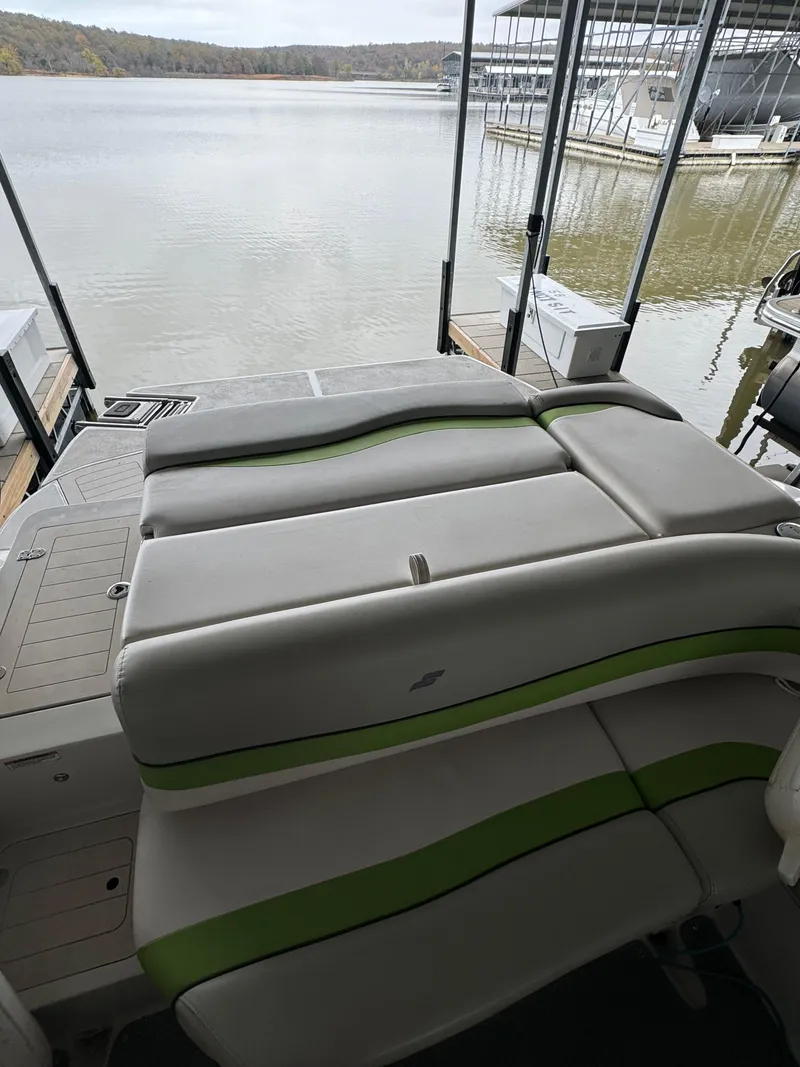 Slide: The Image of 2018 Starcraft Starstep 221 boat interior with green-accented seating, docked by a calm lake. - 4