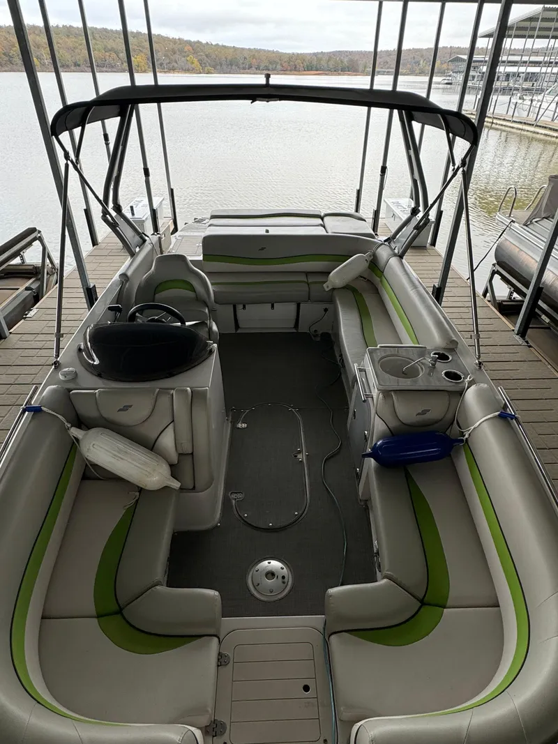 Slide: The Image of 2018 Starcraft Starstep 221 boat interior with seating and steering wheel, docked by a lake. - 5