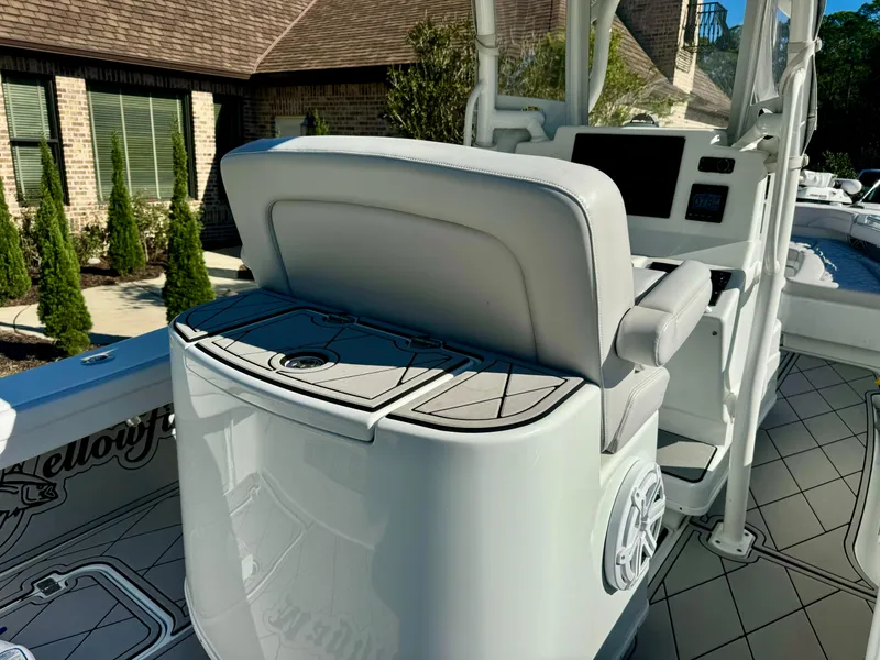 Slide: The Image of 2020 Yellowfin 26 Hybrid boat interior with cushioned seating and control panel. - 10