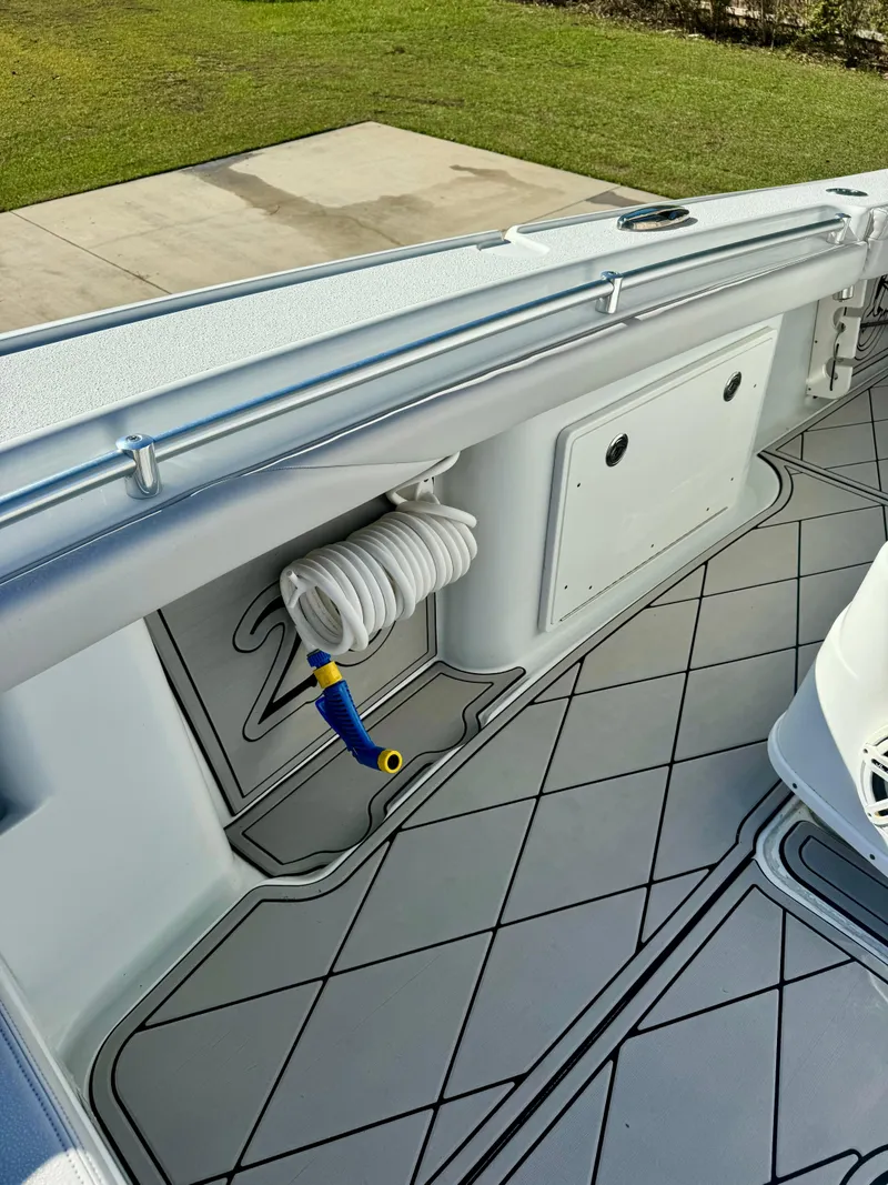 Slide: The Image of 2020 Yellowfin 26 Hybrid boat interior with coiled hose and sleek flooring design. - 14