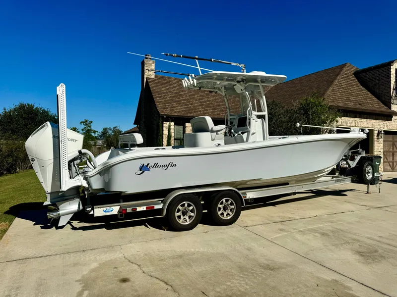 Slide: The Image of 2020 Yellowfin 26 Hybrid boat on trailer in driveway, clear blue sky. - 3