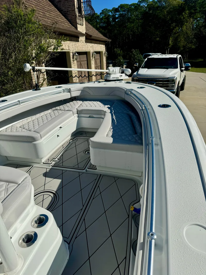 Slide: The Image of 2020 Yellowfin 26 Hybrid boat with spacious seating, parked in a driveway. - 7