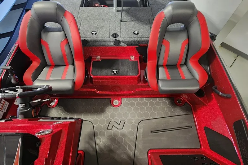 Slide: The Image of 2025 Nitro Z19 boat interior with red and gray seats, steering wheel, and carpeted deck. - 9