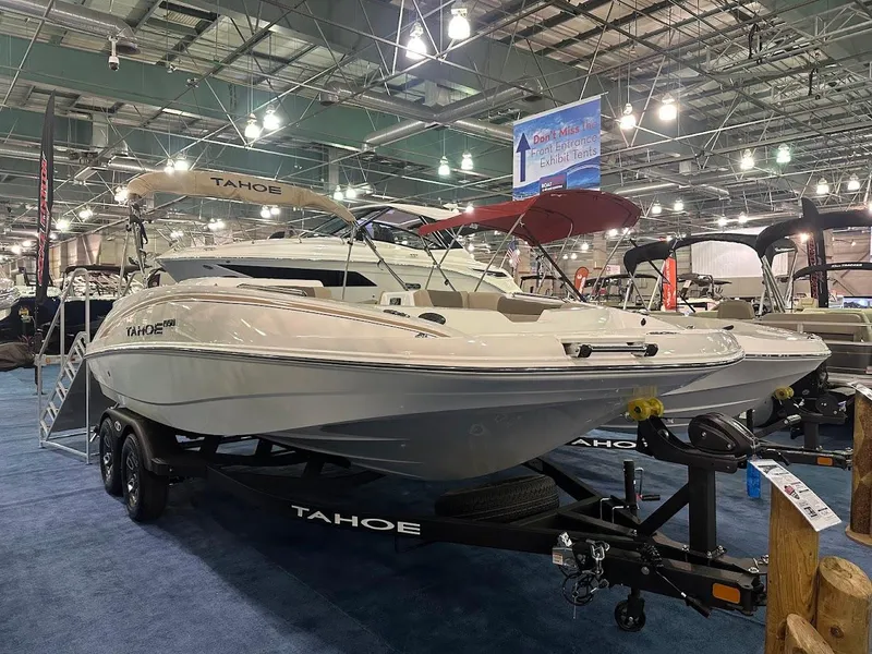 Slide: The Image of 2025 Tahoe 1950 boat displayed indoors on a trailer at a boat show. - 0