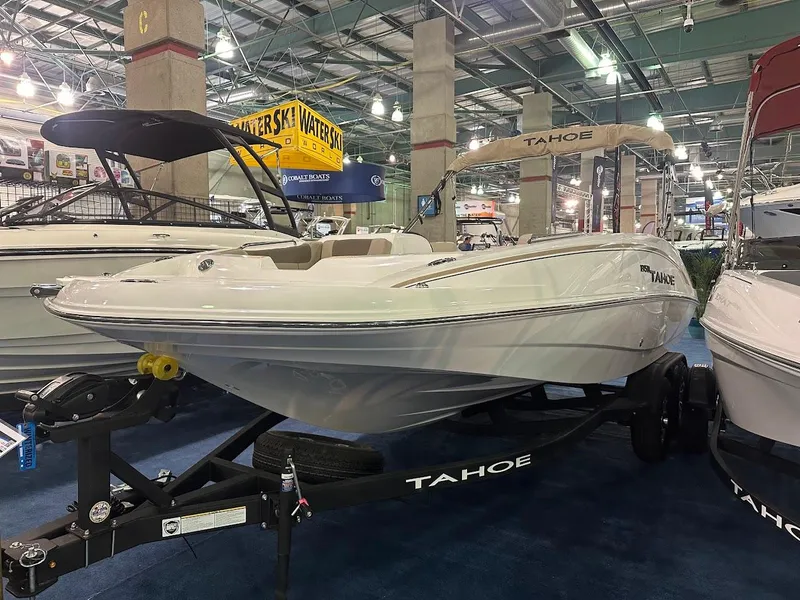 Slide: The Image of 2025 Tahoe 1950 boat displayed at an indoor boat show. - 2