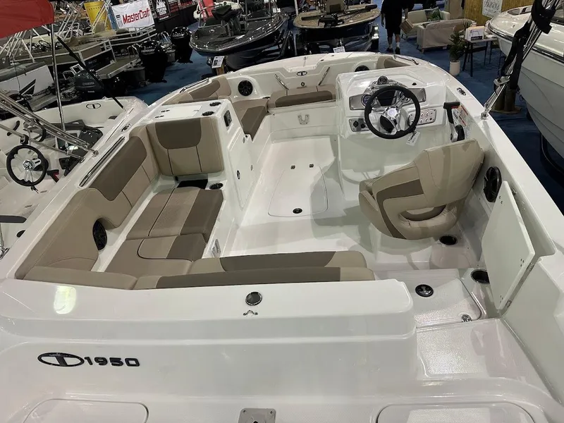 Slide: The Image of 2025 Tahoe 1950 boat interior with beige seating and steering wheel, displayed at a boat show. - 4