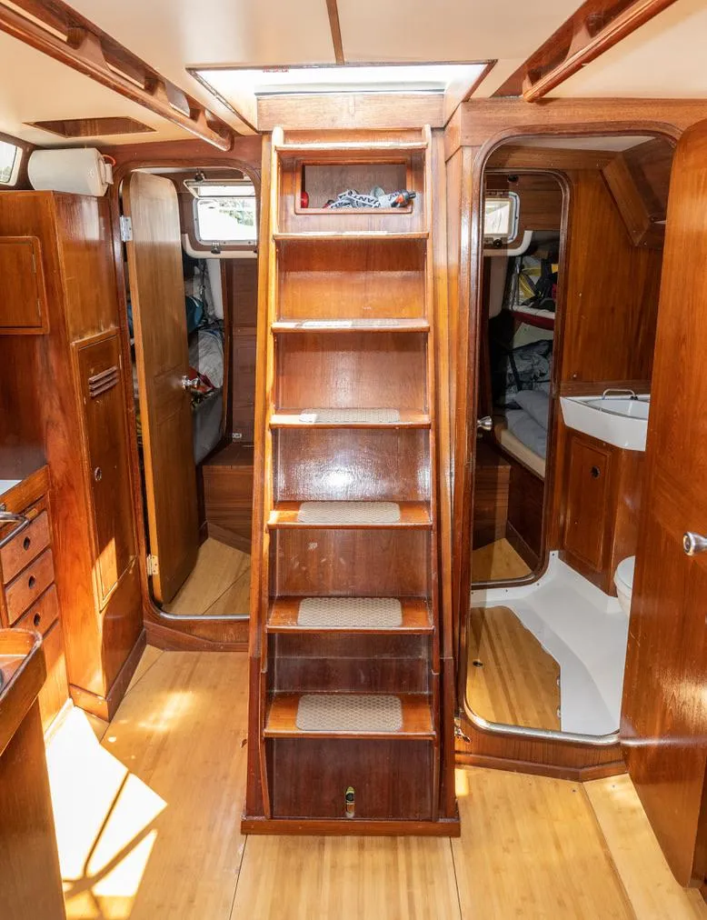 Slide: The Image of Interior of a 1977 Baltic 42 sailboat with wooden cabinetry and ladder. - 18