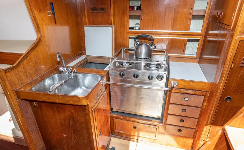 Slide: The Image of 1977 Baltic 42 yacht kitchen with wooden cabinetry and stainless steel appliances. - 19