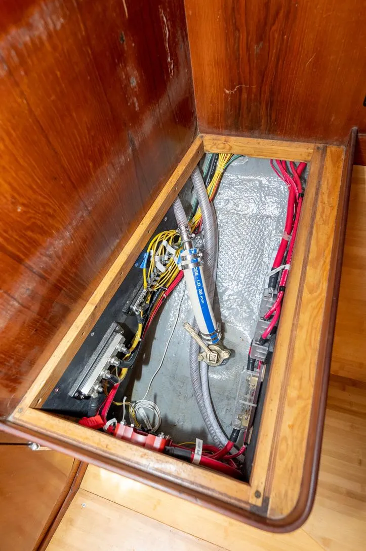 Slide: The Image of Electrical wiring compartment in a 1977 Baltic 42 sailboat, showcasing organized cables and connections. - 22