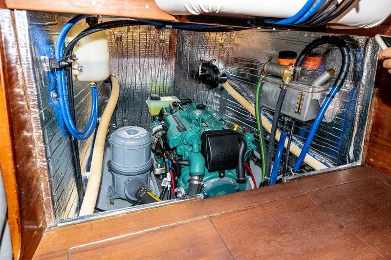 Slide: The Image of Engine compartment of a 1977 Baltic 42 sailboat, featuring a well-maintained marine engine. - 23