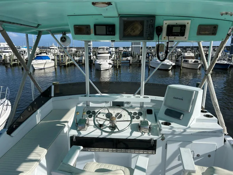Slide: The Image of 1989 Post 43 boat helm with Garmin navigation, docked at marina with multiple boats. - 11