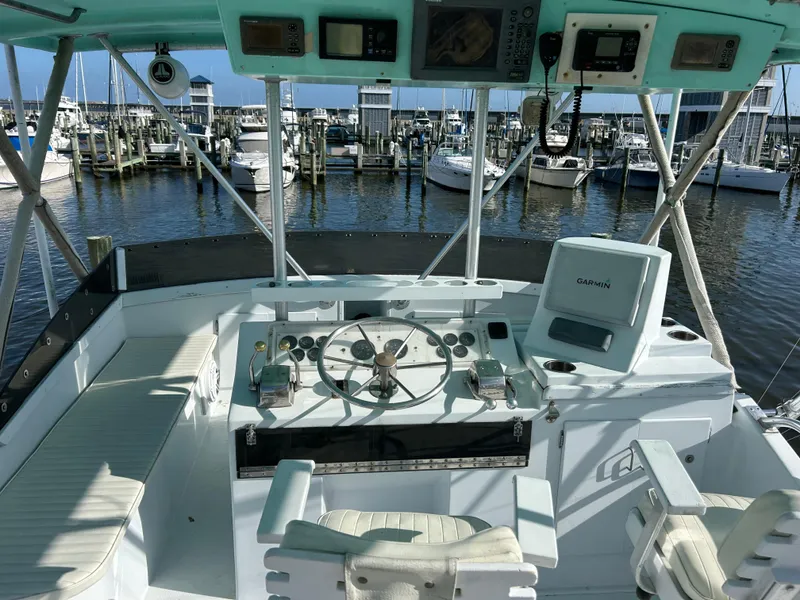 Slide: The Image of Boat cockpit with steering wheel, Garmin navigation, and marina view. Post 43, 1989 model. - 12