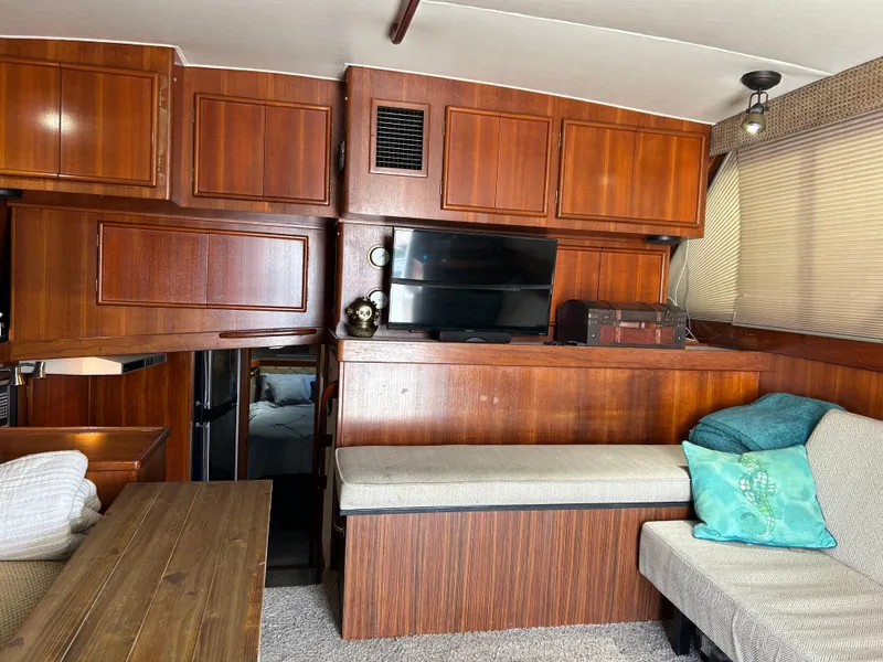 Slide: The Image of Vintage 1989 Post 43 yacht interior with wood paneling, cozy seating, and a TV. - 14