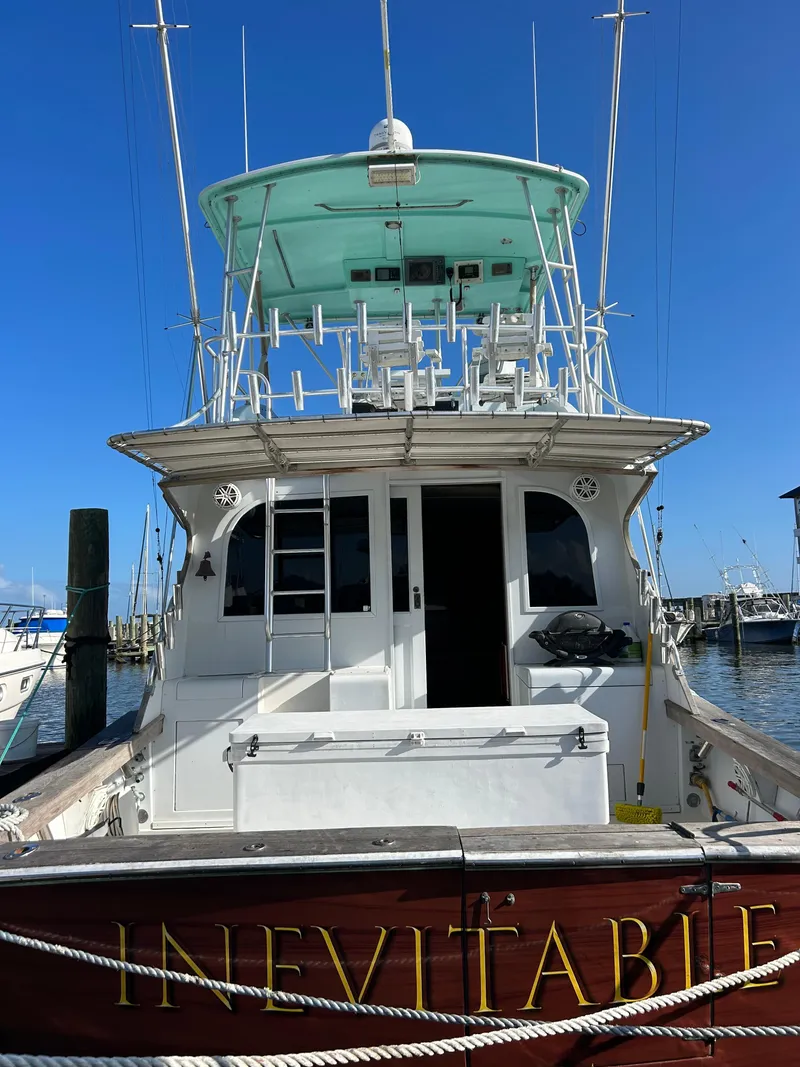 Slide: The Image of 1989 Post 43 boat named "Inevitable" docked at marina under clear blue sky. - 2