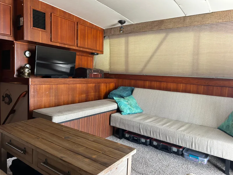 Slide: The Image of Cozy 1989 Post 43 yacht interior with wood paneling, TV, and cushioned seating. - 21