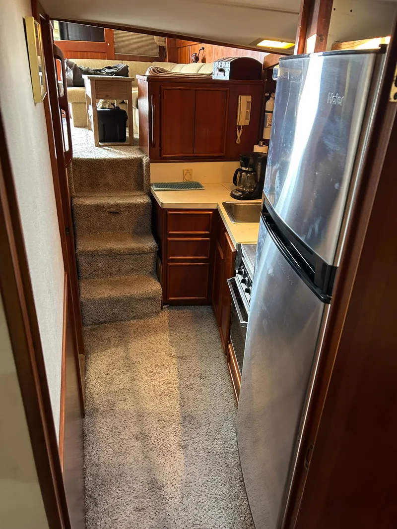 Slide: The Image of Compact kitchen in 1989 Post 43 yacht with stainless steel fridge and carpeted stairs. - 25