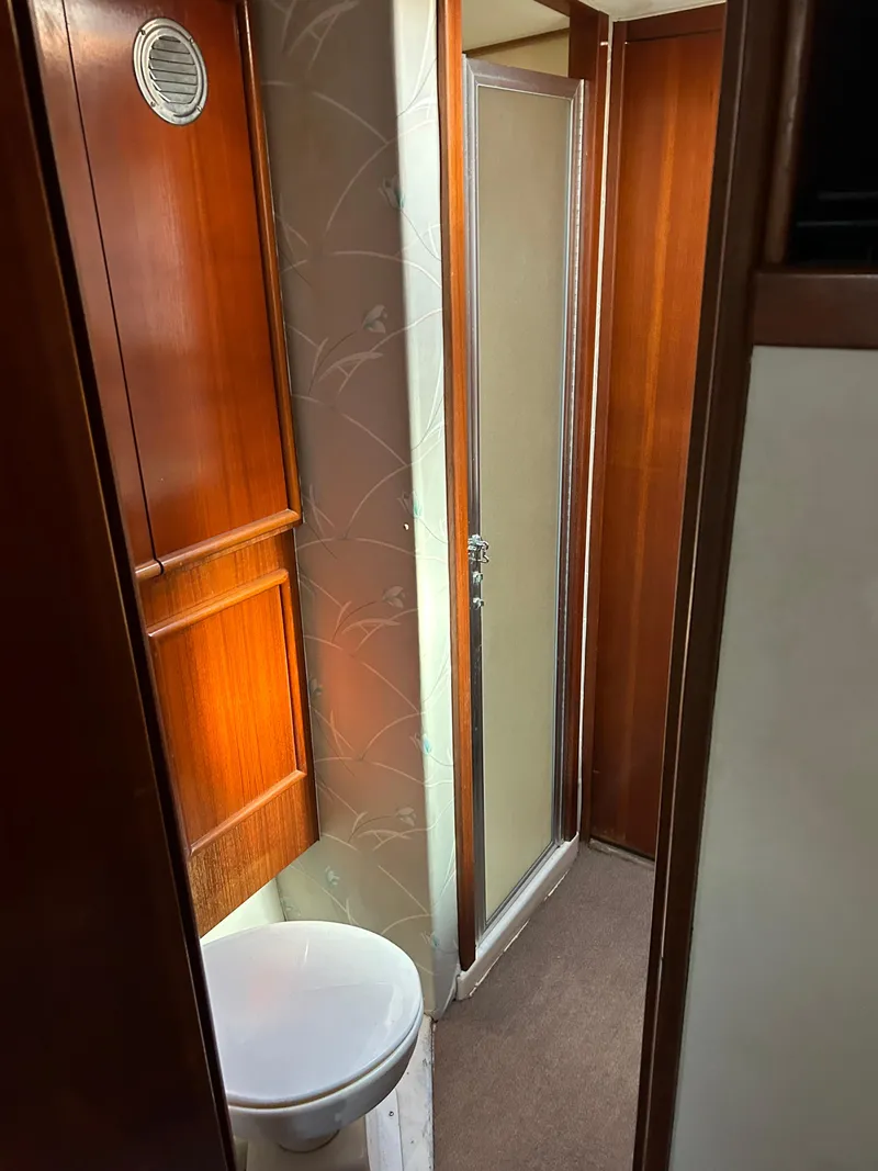Slide: The Image of 1989 Post 43 yacht bathroom with wooden cabinets and shower. - 28