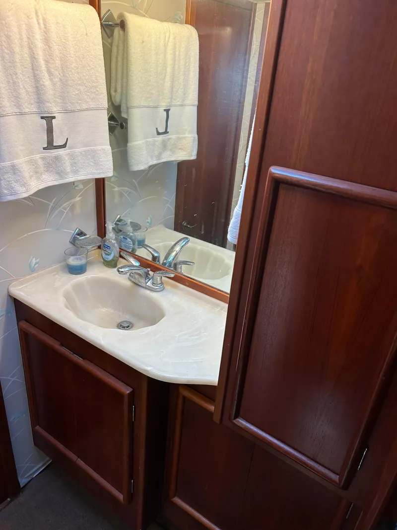 Slide: The Image of Wooden bathroom vanity with mirror, white towels, and sink in a 1989 Post 43 model. - 29