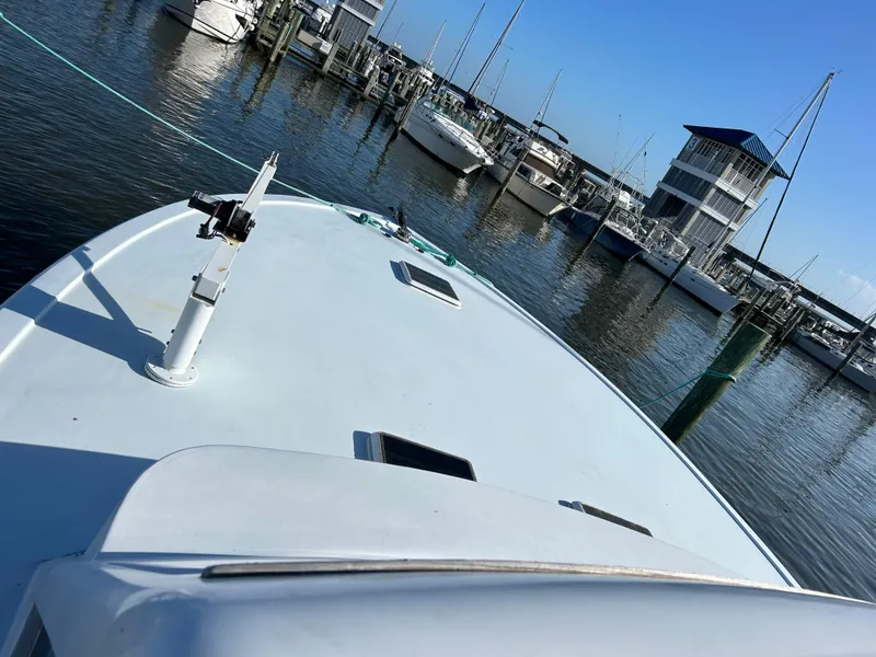 Slide: The Image of Boat docked at marina, Post 43 model, 1989, with clear blue sky. - 3