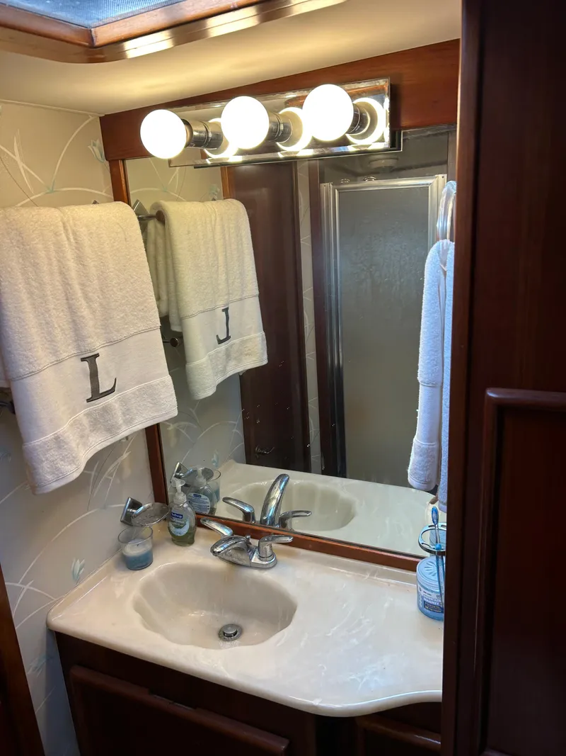 Slide: The Image of Elegant bathroom vanity with mirror, towels, and lighting in a 1989 Post 43 model. - 30